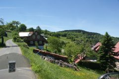 Ortsdurchfahrt mit typischem Holzhaus in Nordtschechien